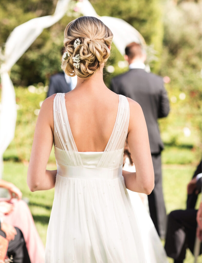 Bride preparing to walk down the isle as her wedding photographer captures the scene.