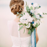 A wedding photographer artfully capturing a bride during her wedding day.