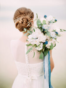 A wedding photographer artfully capturing a bride during her wedding day.