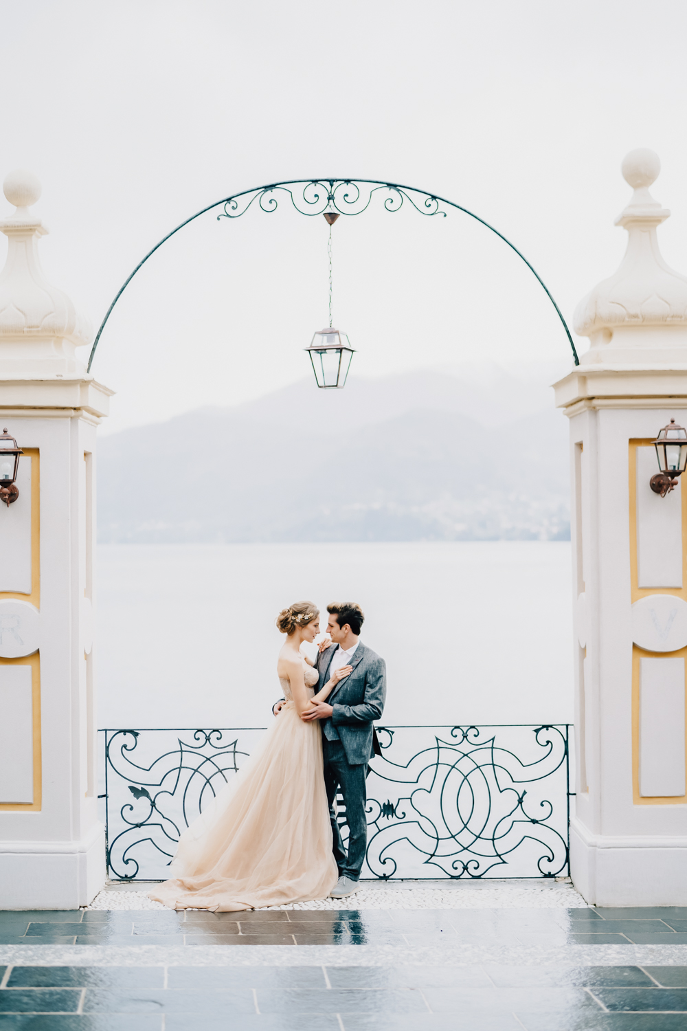 A couple sharing a romantic moment at a picturesque wedding venue in Europe.