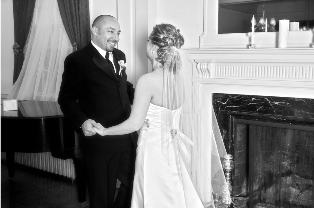 A bride shares a first look with her father in a timeless black and white photograph.