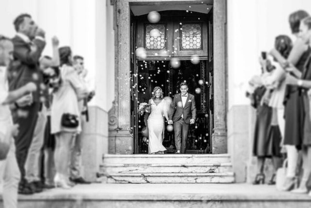 A bride and groom exit the venue having been captured by their independently hired photographer.