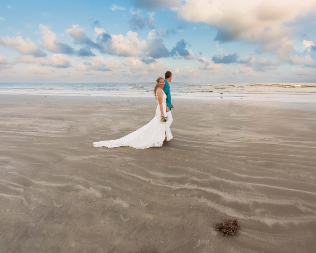 Beach Galveston Wedding Venues are romantic backdrops for your special day, as depicted by this bride and groom walking at sunset.